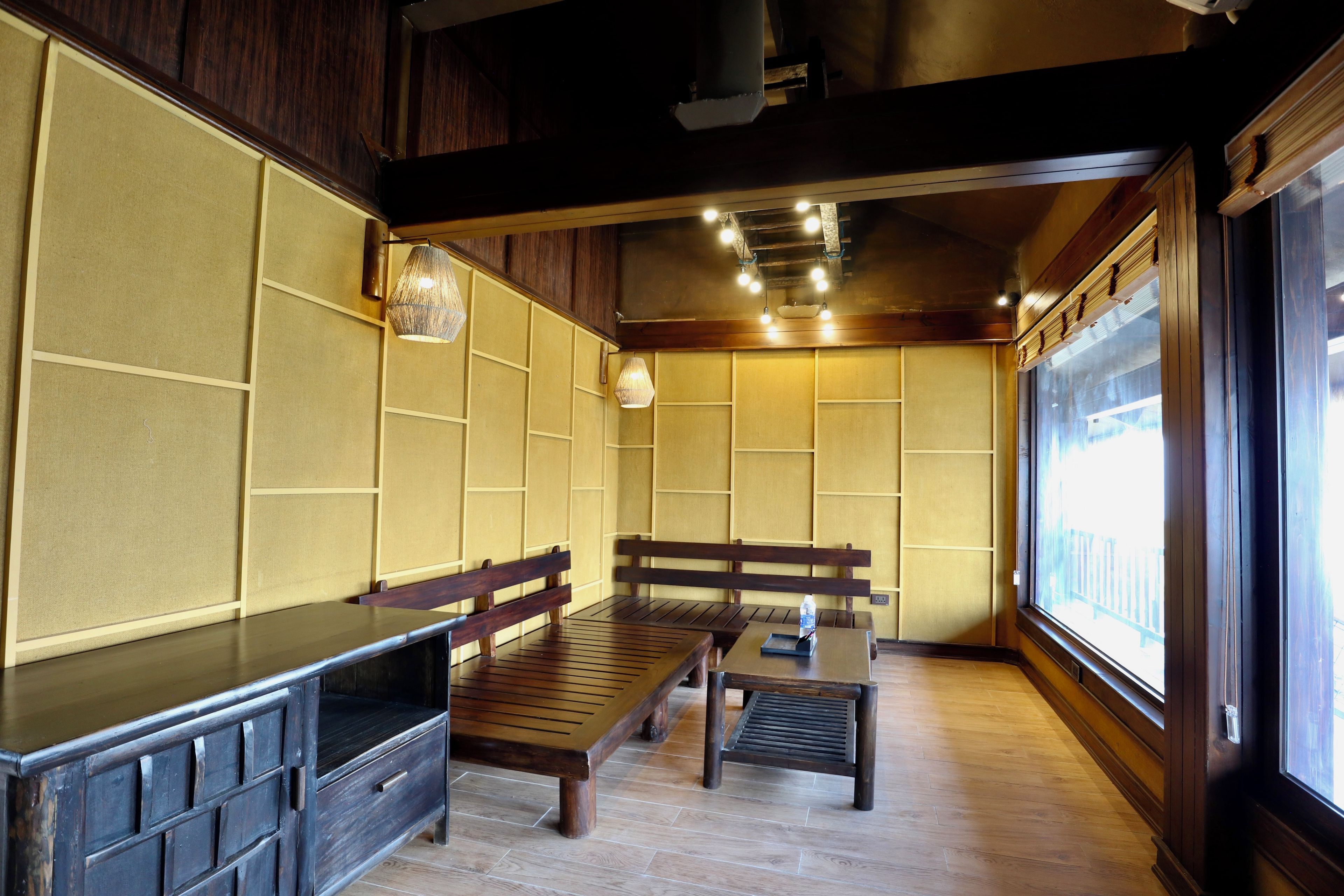 A room with wooden benches, a table, and a window.