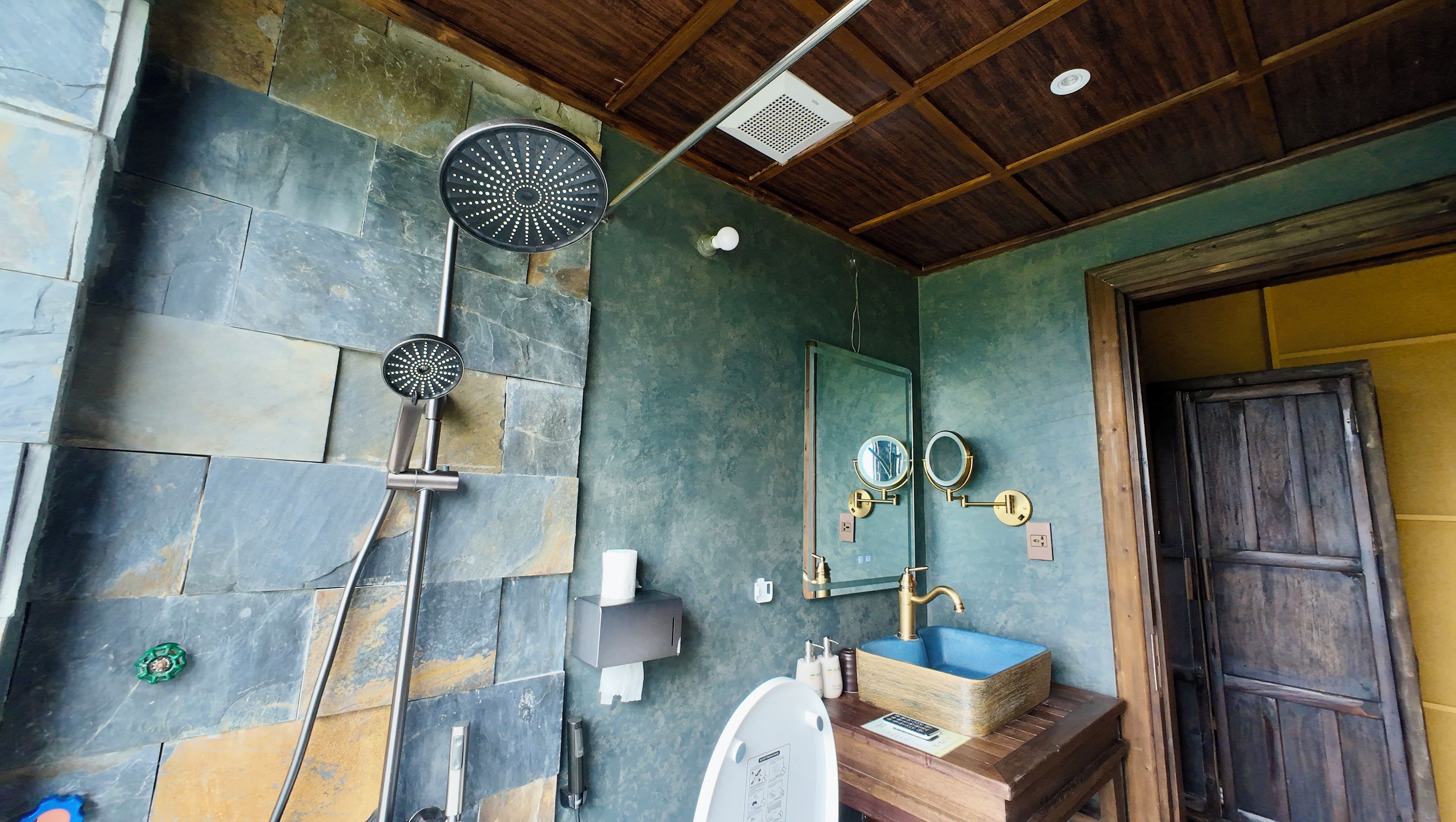 A bathroom with a shower, a sink, and a mirror.