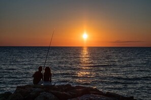 Two people fishing at sunset by the sea. - Argentario Giannutri: Superior Two-Bedroom Apartment, Sleeps 4 (Orbetello)