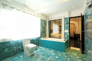 Une salle de bain équipée de toilettes, d’une baignoire et d’une douche.