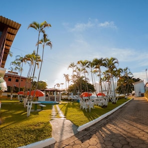 A resort with outdoor seating, palm trees, and a clear sky. - Hotel Recanto dos Passaros de Sao Sebastiao (São Sebastião)