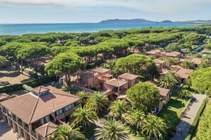 A coastal resort with villas, palm trees, and a view of the sea. - Argentario Giglio, Superior Two-Bedroom Apartment, Sleeps 4 (Albinia)
