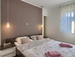 A bedroom with a bed, bedside tables, and a window with curtains. - Verde Comfortable Holiday Residence (Pula)