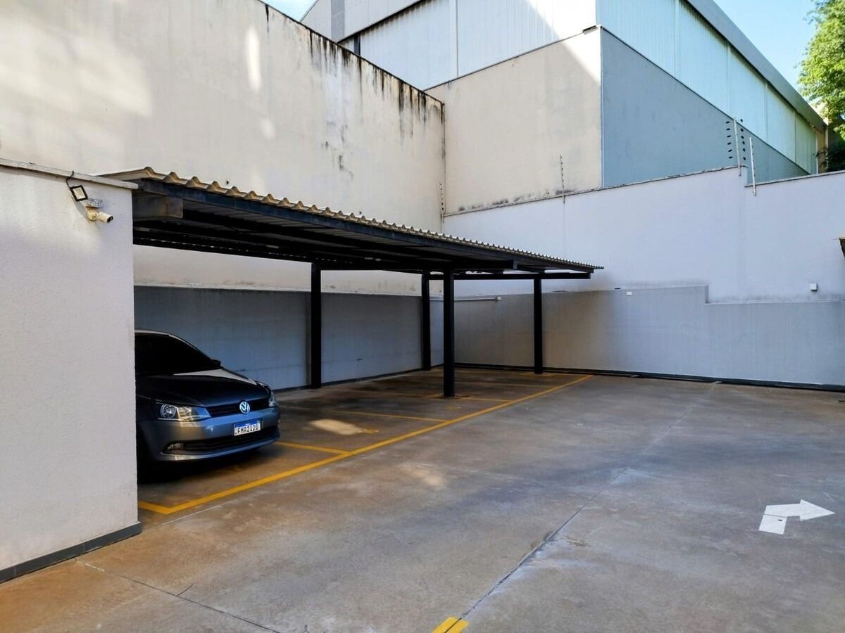 Un’area di parcheggio con un’auto parcheggiata sotto una copertura.