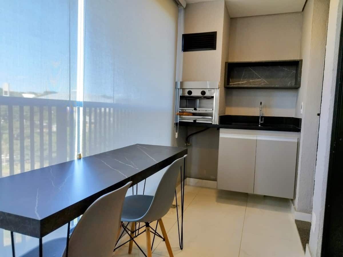 A compact kitchen with a dining area, including a table and chairs, a built-in oven, and a small countertop.