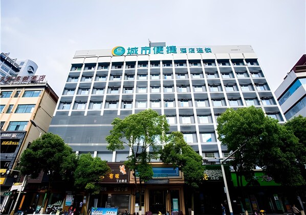 Un hôtel à plusieurs étages doté d’une façade moderne, avec un logo bien visible sur le dessus.