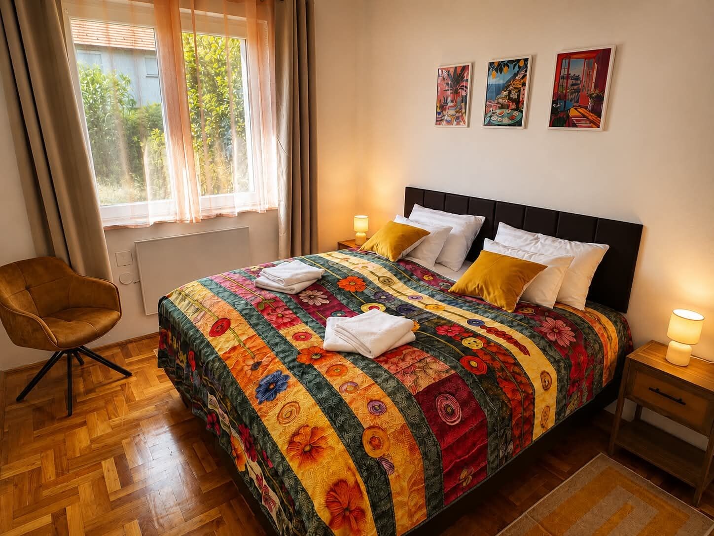 Une chambre à coucher avec un lit, une chaise, une fenêtre avec des rideaux et des œuvres d’art murales.