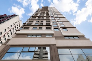 A high-rise building with multiple floors, large windows, and a clear sky. - Aconchego em Perdizes | Ao lado do Allianz Parque (São Paulo)