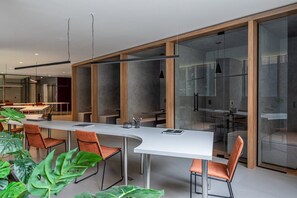 Een moderne vergaderruimte met een lange tafel, stoelen en glazen scheidingswanden.