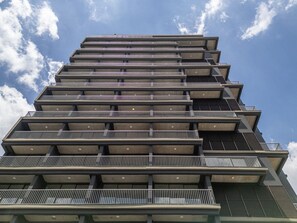 Ein mehrstöckiges Gebäude mit Balkonen und einem klaren Himmel im Hintergrund.