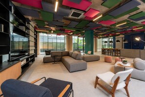 Eine moderne Lounge mit einem Ecksofa, einem Flachbildfernseher und einer Bar.