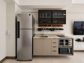 A modern kitchen with a built-in refrigerator, double oven, and microwave. - Onde a Privacidade Encontra a Elegância República (Santa Ifigênia)