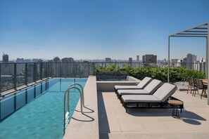 Une piscine sur le toit offrant une vue dégagée sur les gratte-ciel de la ville.