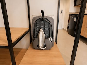 Ein Zimmer mit einer Küchenzeile, einem grauen Kinderwagen und einem Holzboden.