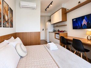 A hotel room with a bed, a desk, a TV, and a kitchenette. - República, Centro de São Paulo, metrô ao lado (Santa Ifigênia)