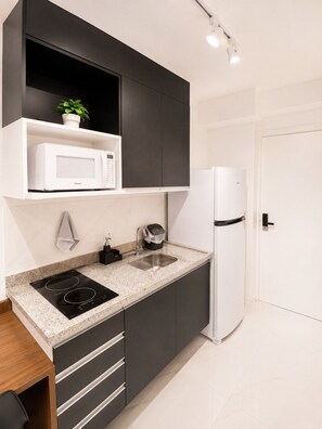 Eine moderne Küche mit Mikrowelle, Kaffeemaschine und Kühlschrank.