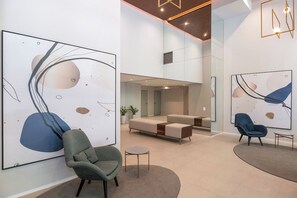 Ein modernes Interieur mit abstrakter Kunst, einer Couch und zwei Sesseln.