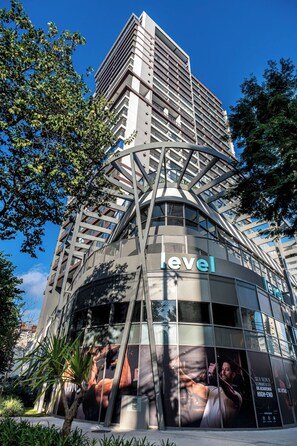 Ein modernes Hotelgebäude mit einem markanten Schild mit dem Schriftzug 'level', das ein einzigartiges architektonisches Design mit einem zentralen Atrium und großen Fenstern aufweist.
