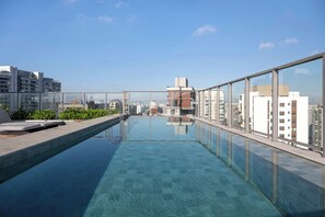 A rooftop swimming pool with glass railings and a city view. - 1 Dormitório | 1 Vaga no coração do Brooklin (São Paulo)