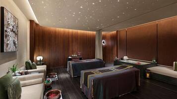 Un moderno spa con techo de madera, dos camillas de masaje, una mesa de masaje y un mostrador de recepción.