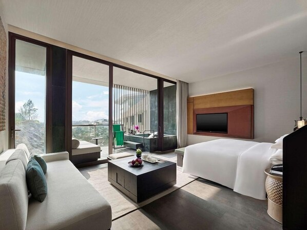 A modern hotel room with a large bed, a sofa, a coffee table, and a TV. - Banyan Tree Nanjing Garden Expo (Nanjing)