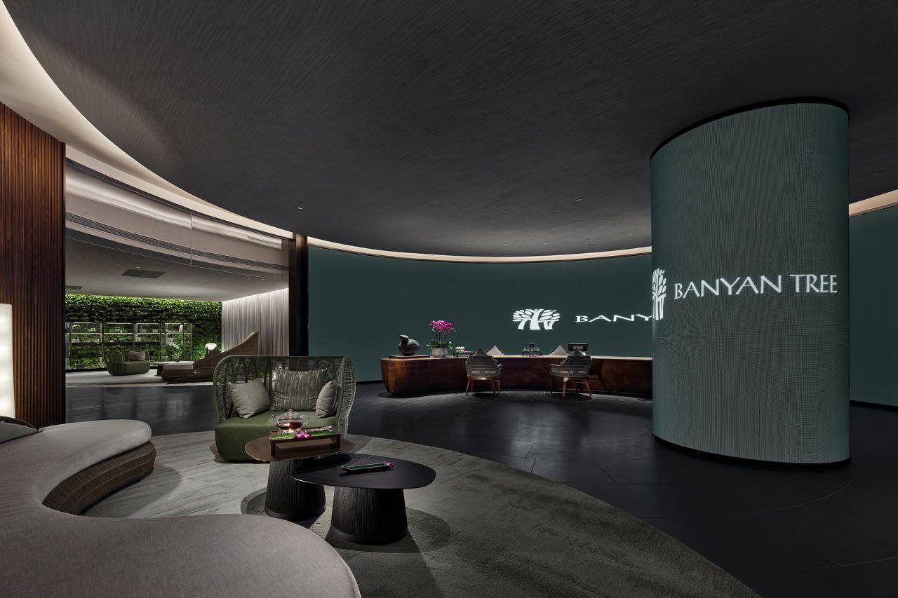 A modern interior with a reception desk, seating area, and a large cylindrical column.