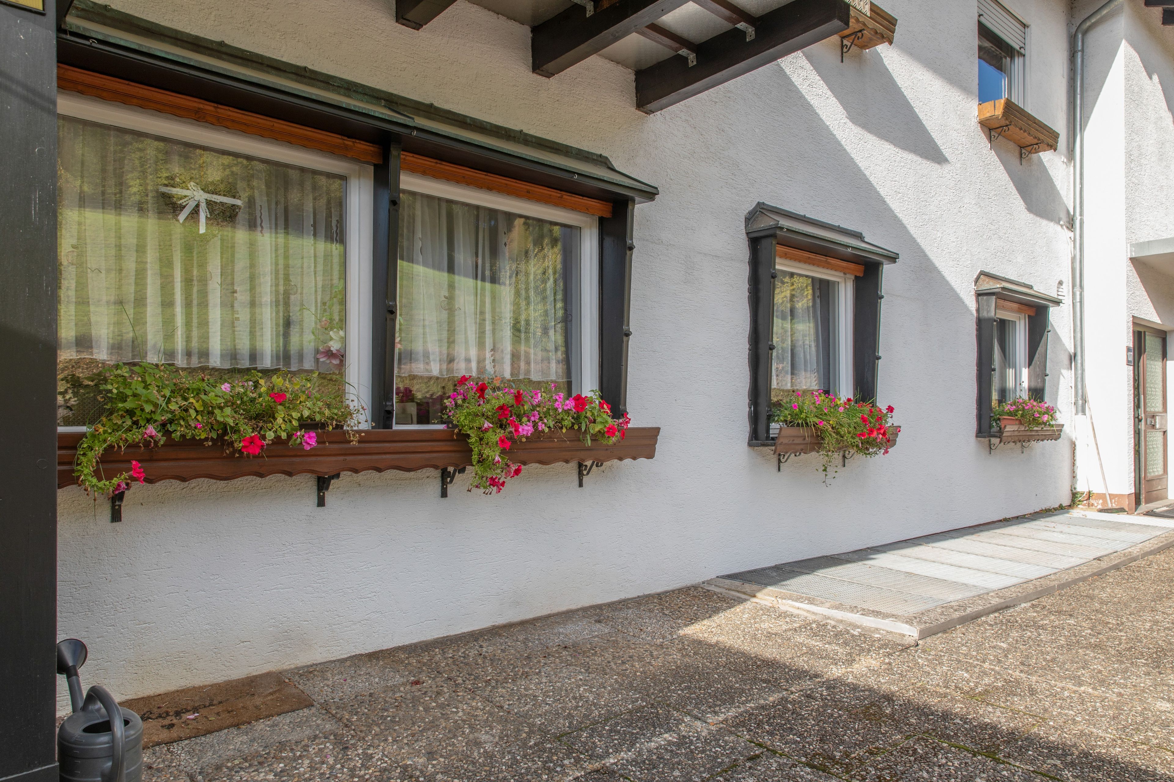Ein Gebäude mit zahlreichen Fenstern, einige mit Blumenkästen.