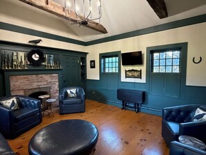 A room with a fireplace, two sofas, a coffee table, and a ceiling fan. - The Crow and Stone - Great Location (Fly Creek)