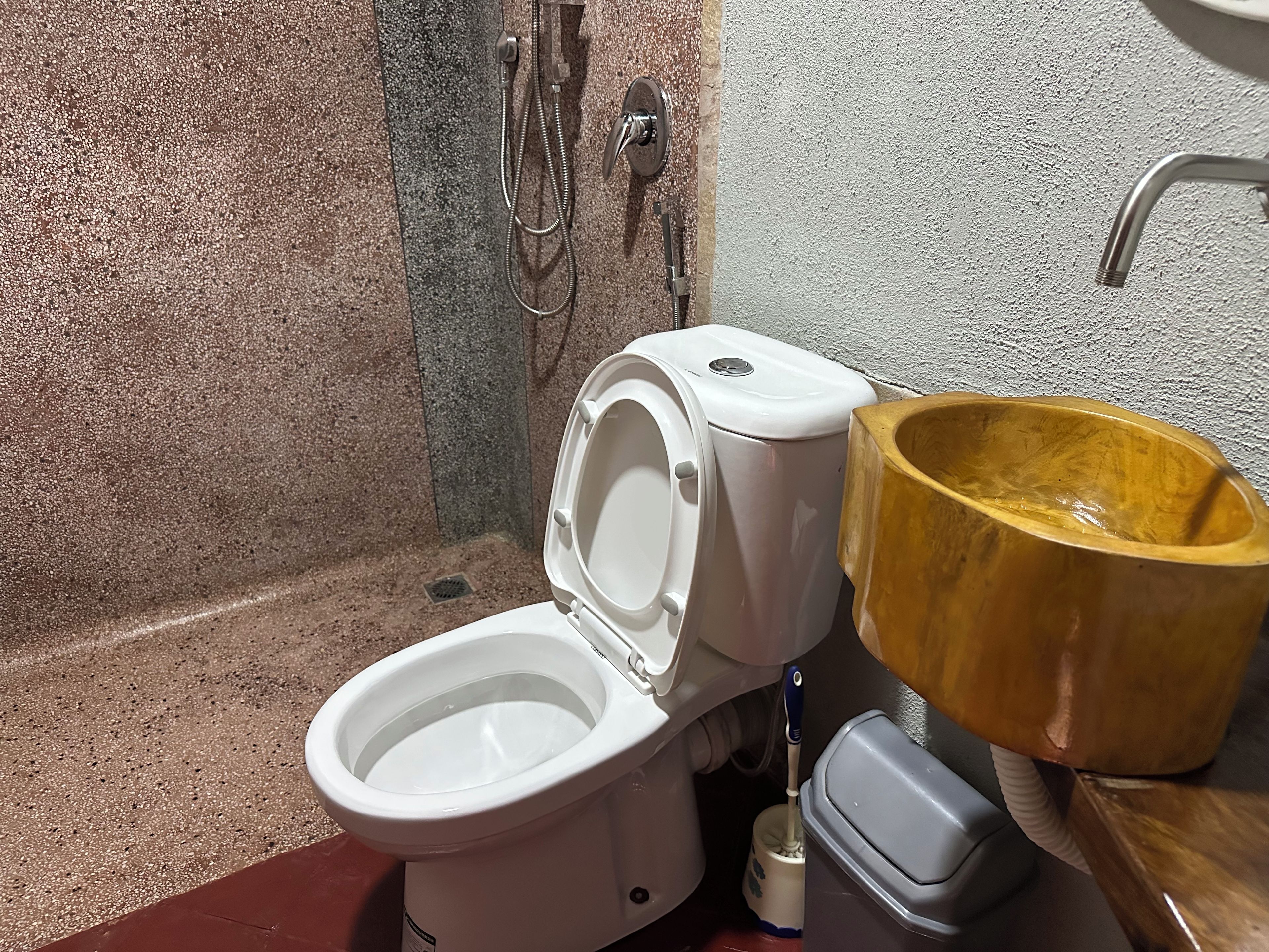Une salle de bain avec des toilettes, une douche et un lavabo en bois.
