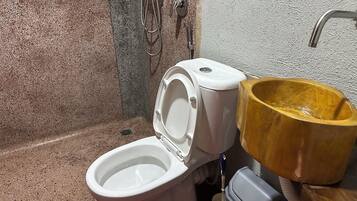 Une salle de bain avec des toilettes, une douche et un lavabo en bois.