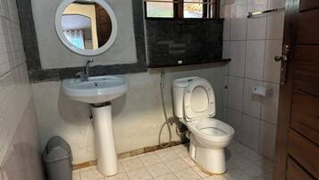 Un baño con lavamanos, inodoro y espejo.
