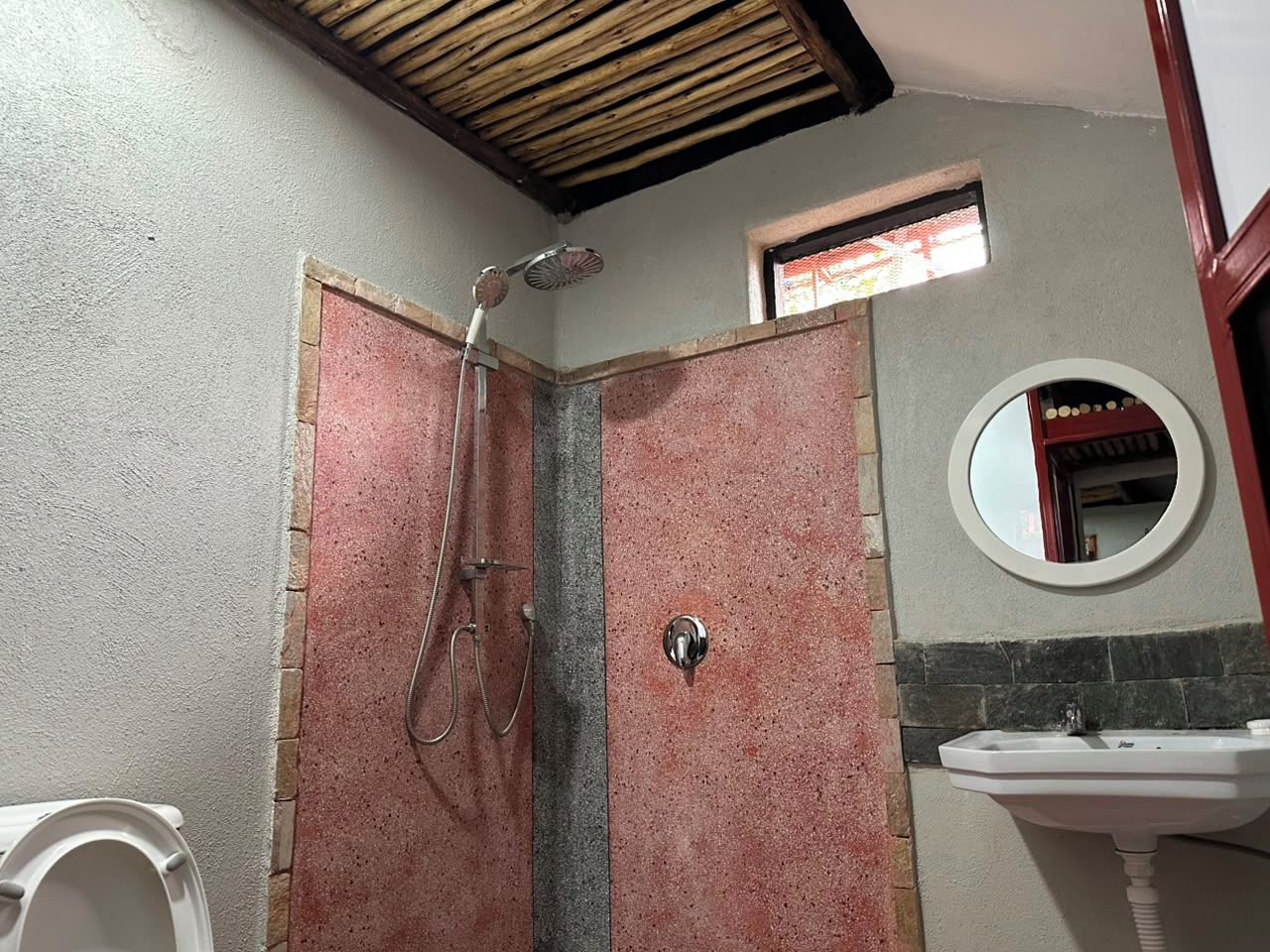 Un baño con ducha, lavabo y espejo.