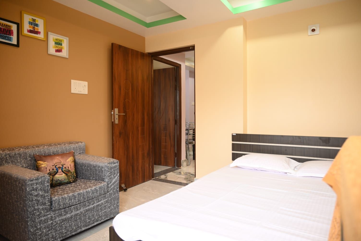 Una habitación de hotel con una cama, un sofá y una puerta de madera.