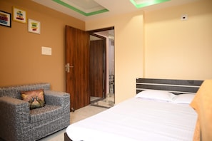 Une chambre d’hôtel avec un lit, un canapé et une porte en bois.