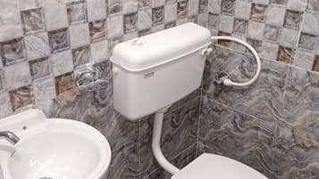 A bathroom with a toilet, bidet, and sink.