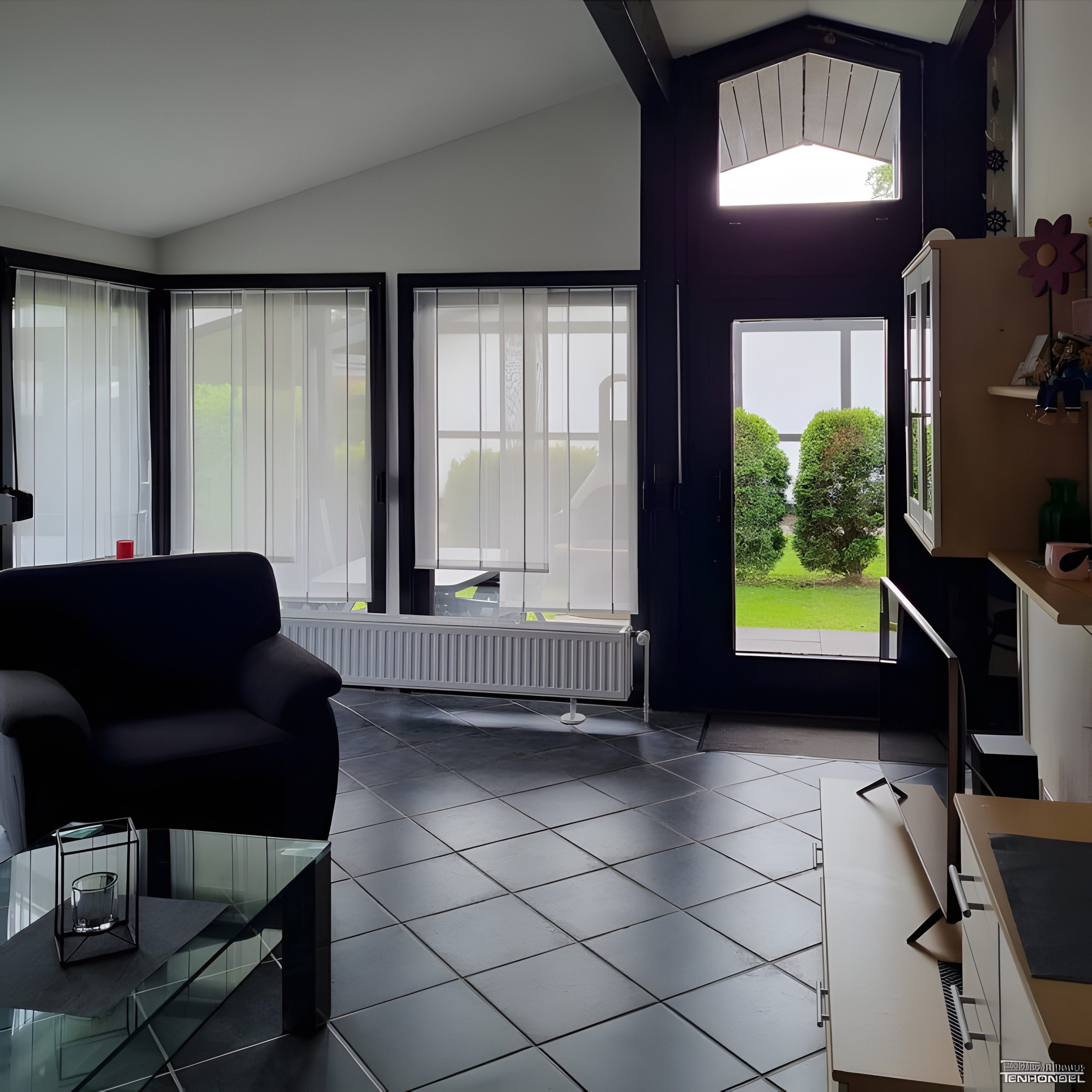 A modern living room with a black sofa, a glass coffee table, and a view of a garden through large windows.