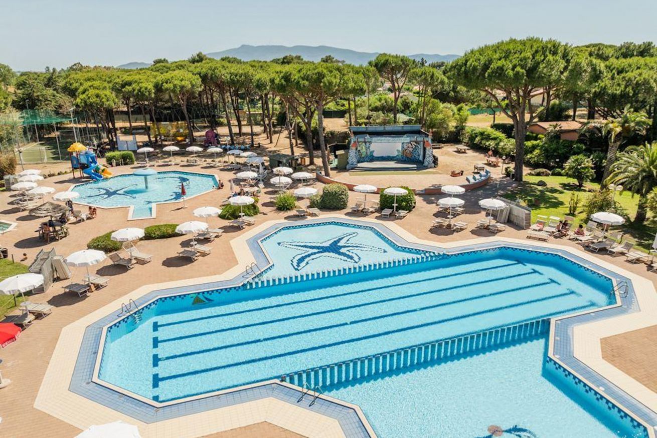 A resort with multiple swimming pools, sun loungers, and shaded areas.