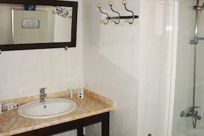 Ein Badezimmer mit Waschbecken, Spiegel und Dusche.