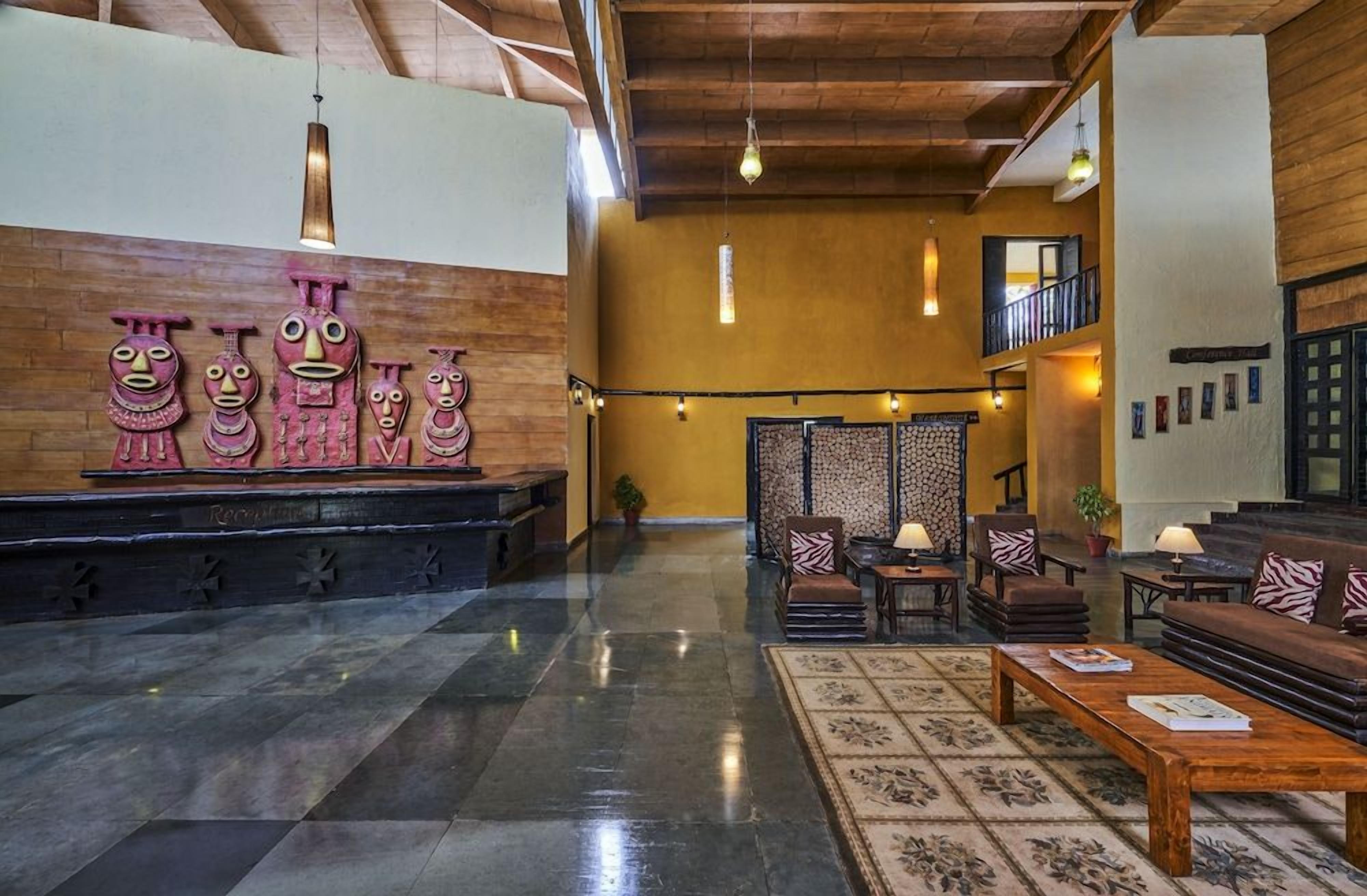 A lobby with a reception desk, seating area, and decorative wall art.