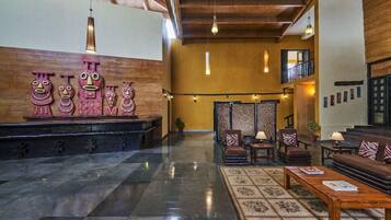 A lobby with a reception desk, seating area, and decorative wall art.