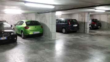 Un parcheggio con pilastri in cemento e illuminazione al neon.