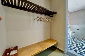 Un baño con una banca, toallero y suelo estampado.