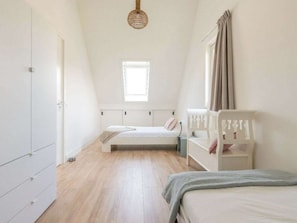 A bedroom with a bunk bed, a wardrobe, a window, and a hanging light fixture. - The Beach Forest House (Burgh-Haamstede)