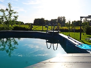 A swimming pool with a diving board and a grassy area in the background. - Spa'nsea Bungalow (Stepnica)