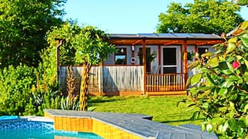 Une propriété résidentielle dotée d’une piscine, d’une terrasse en bois et d’un jardin clôturé.