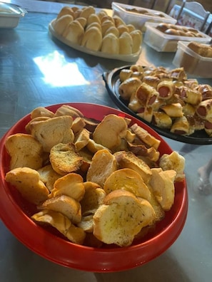 A table with various food items including bread rolls and breadsticks. - Pousada Paraguaya (Angra dos Reis)