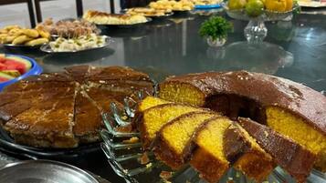 Una mesa de buffet con diversos alimentos, incluyendo un pastel y fruta.