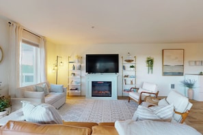 A living room with a fireplace, a television, and seating arrangements. - Pickleball, Hot tub, beach access, (OBreeze) (Westport)