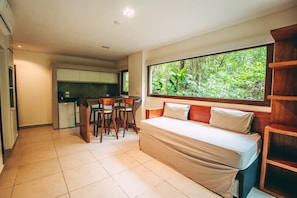 A compact room with a bed, a small kitchen area, and a dining table. - Tre Iguazu Hotel (Puerto Iguazú)