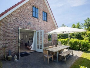 Ein Ziegelhaus mit offener Tür, die in einen Innenraum führt.